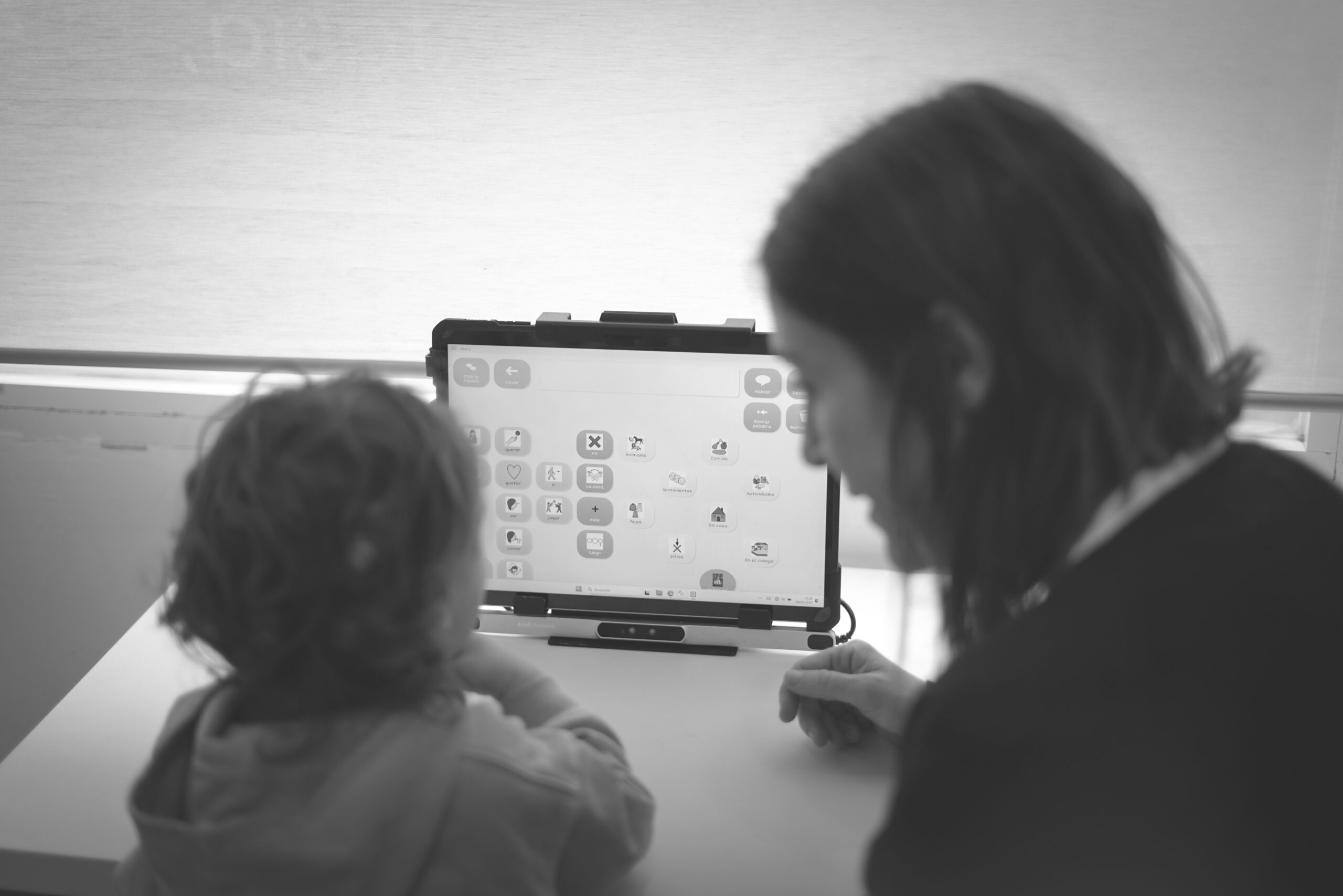 Logopeda trabajando con un niño con un comunicador de pictogramas (SAAC) en Ahotsa, Getxo